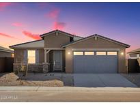 Single-story home with gray garage doors and stone accents at 37405 W San Clemente St, Maricopa, AZ 85138