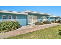 Charming blue single-story home with a well-maintained lawn and manicured landscaping at 10026 W Lancaster Dr, Sun City, AZ 85351