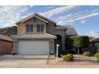 Charming two-story home with a well-manicured front yard and a two-car garage in a suburban neighborhood at 1926 E Siesta Ln, Phoenix, AZ 85024