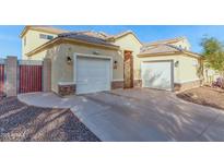 Two-car garage, light-colored exterior, and a landscaped front yard at 1430 E Valencia Dr, Phoenix, AZ 85042