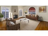 Bright living room features a cozy fireplace, large windows and neutral decor at 1346 W Willetta St, Phoenix, AZ 85007