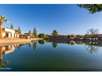Scenic waterfront view of the community featuring lush landscaping and building reflections on the calm lake at 2107 S Paseo Loma --, Mesa, AZ 85202