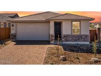 Charming single-story home featuring a brick driveway, attached garage, and inviting entrance at 16923 W Siesta Way, Goodyear, AZ 85338
