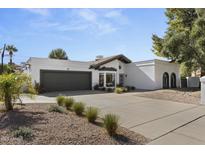 White single-story home with gray garage door and landscaped front yard at 7805 E North Ln, Scottsdale, AZ 85258