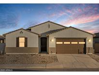 One-story home with brown garage door and desert landscaping at 37034 W La Paz St, Maricopa, AZ 85138