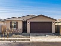 Charming single-story home with a two-car garage, stone accents, and low-maintenance landscaping at 16035 W Desert Hollow Dr, Surprise, AZ 85387