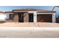 Charming single-story home featuring a brick facade, a two-car garage, and desert landscaping at 1284 E Coconino Way, Gilbert, AZ 85298