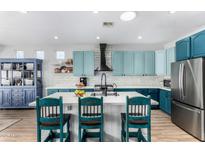 Modern eat-in kitchen featuring a large island with seating and stainless steel appliances at 22004 W Moonlight Path, Buckeye, AZ 85326
