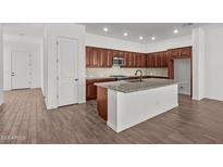 Modern kitchen features wood cabinets, granite counters, stainless appliances, and large center island at 12308 W Parkway Ln, Avondale, AZ 85323