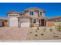 Charming two-story home with a three-car garage, desert landscaping, and a brick paver driveway at 18746 E Panchito Dr, Gold Canyon, AZ 85118