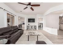 Bright living room boasts hardwood floors, a ceiling fan, and neutral-colored walls at 520 S Brett St, Gilbert, AZ 85296