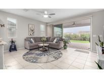 Bright living room with tile floors, plush sectional sofa, and sliding glass doors to the patio at 17879 W Hiddenview Dr, Goodyear, AZ 85338