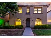 Charming two-story home with landscaped front yard and a tiled roof, illuminated by warm interior lighting at 955 S Henry Ln, Gilbert, AZ 85296