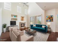 Bright living room with vaulted ceilings, fireplace, and teal sofa at 16420 N Thompson Peak Pkwy # 1009, Scottsdale, AZ 85260