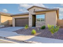 Charming single-story home featuring a desert landscape, stone accents, and a two-car garage at 23461 N 76Th Pl, Scottsdale, AZ 85255