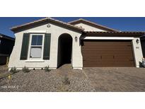 Charming single-story home showcasing a well-manicured front yard and a two-car garage at 21565 N Rummler Ln, Maricopa, AZ 85138