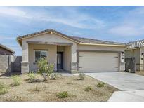 Charming single-story home with a desert landscaped front yard, two car garage, and neutral color palette at 24586 W St Anne Ave, Buckeye, AZ 85326