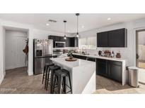 Bright kitchen with stainless steel appliances, a waterfall island, and black cabinetry at 8913 E Oro Cir, Mesa, AZ 85212