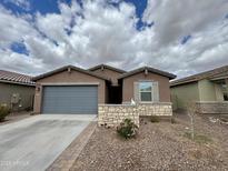Charming single-story home featuring desert landscaping, a two-car garage, and a welcoming facade at 5636 W Jackalope Ln, Laveen, AZ 85339