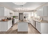 Modern kitchen with white cabinets, granite counters, and stainless steel appliances at 1719 E Verde Ln, Phoenix, AZ 85016