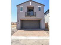 Modern home showcasing a gray exterior, balcony, brick-lined garage, and brick-paved driveway on a sunny day at 2445 W Rowel Rd, Phoenix, AZ 85085