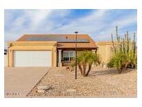 Desert landscape surrounds this single-story home with solar panels and a two-car garage at 6908 W Sunnyside Dr, Peoria, AZ 85345