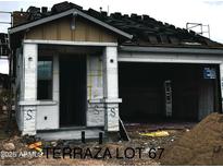 New construction shows in this elevation with an unfinished exterior, showing the roof partially shingled and covered porch at 5664 N 205Th Ln, Buckeye, AZ 85396
