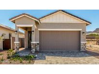 Charming home featuring a two-car garage, stone accents, and neutral stucco at 5664 N 205Th Ln, Buckeye, AZ 85396