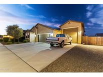 Charming home with a well-maintained front yard, long driveway, and spacious three-car garage with pickup truck at 18428 W Robin Ln, Surprise, AZ 85387