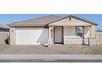Single-story home with a white door, stone accents, and a two-car garage at 17732 W Coolidge St, Goodyear, AZ 85395