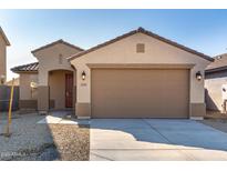 Tan house with a two-car garage and red front door at 23235 W Florence Ave, Buckeye, AZ 85326