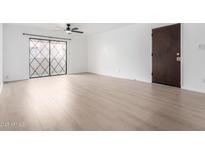Bright living room featuring laminate floors and sliding glass doors at 1920 W Lindner Ave # 229, Mesa, AZ 85202