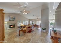 Expansive living room with fireplace, vaulted ceilings, tile floors, and an open floor plan for entertaining at 3935 N 151St Ave, Goodyear, AZ 85395