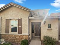 Charming front exterior featuring stone accents, a welcoming entrance, and well-maintained landscaping at 1948 W Busoni Pl, Phoenix, AZ 85023