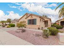 Charming single-story home with a well-maintained front yard and desert landscaping under a blue cloudy sky at 18066 W Weatherby Dr, Surprise, AZ 85374