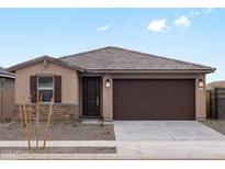 Charming single-story home with a stone-accented facade, a two-car garage, and a well-manicured front yard at 15995 W Cottontail Ln, Surprise, AZ 85387