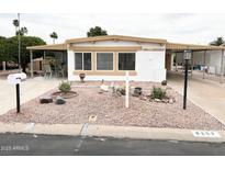 Charming single-story home with desert landscaping and a covered carport at 8257 E Dutchman Dr, Mesa, AZ 85208