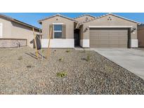 Inviting single-story home with a two car garage and desert landscaping at 16034 W Desert Hollow Dr, Surprise, AZ 85387