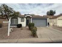 Charming single-story home with desert landscaping, a two-car garage, and neutral color scheme at 1812 E Peach Tree Dr, Chandler, AZ 85249