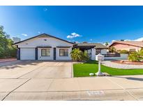 Charming single-story home with a well-manicured front yard and a spacious two-car garage at 5038 W Echo Ln, Glendale, AZ 85302