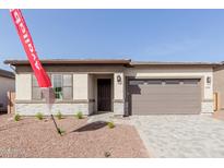 Charming single-story home with a stone facade, desert landscaping, and a two-car garage at 17594 W Blue Sky Dr, Surprise, AZ 85387