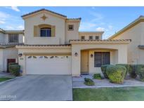 Two-story house with tan exterior, two-car garage, and landscaped yard at 2067 W Periwinkle Way, Chandler, AZ 85248