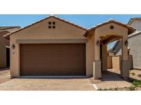 Inviting single-story home featuring a two-car garage, covered entryway, and desert landscaping at 5656 N 205Th Ln, Buckeye, AZ 85396