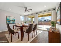 Bright dining room with modern table, natural light, and sliding door to patio at 8828 S 167Th Ln, Goodyear, AZ 85338