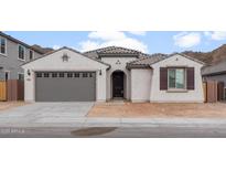 One-story home with gray garage door and brown shutters at 7124 W Gambit Trl, Peoria, AZ 85383