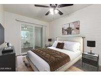 Bright bedroom with a sliding glass door, plush bedding, and contemporary décor at 2608 W Berridge Ln # 220, Phoenix, AZ 85017