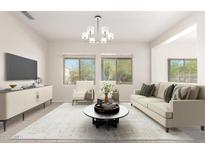 Bright living room featuring large windows, neutral tones, and modern chandelier at 21067 N Sequoia Crest N Dr, Surprise, AZ 85387