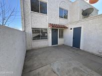 Two-story stucco building with private patio and gray door at 5238 N 42Nd Ln, Phoenix, AZ 85019