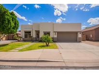 Contemporary home with a well-maintained front yard, desert landscaping, and a spacious two-car garage at 10101 E Posada Ave, Mesa, AZ 85212