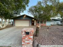Ranch-style home with brick accents and a two-car garage at 5634 W Zoe Ella Way, Glendale, AZ 85306